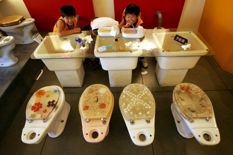 Дети едят мороженое из миниатюрных туалетов в тематическом ресторане в Гаосюне, Тайвань