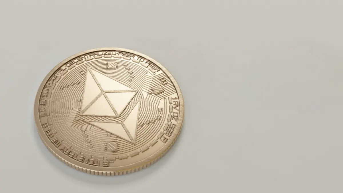 A coin with a cryptocurrency symbol on a grey background