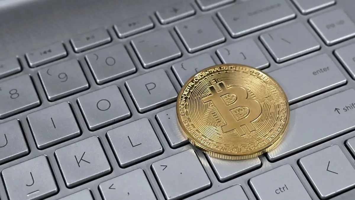 Ноутбук пернетақтасындағы биткоин белгісі бар монета