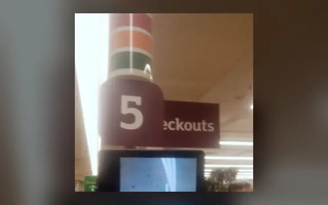 Камера и экран у касс самообслуживания в магазине Sainsbury's